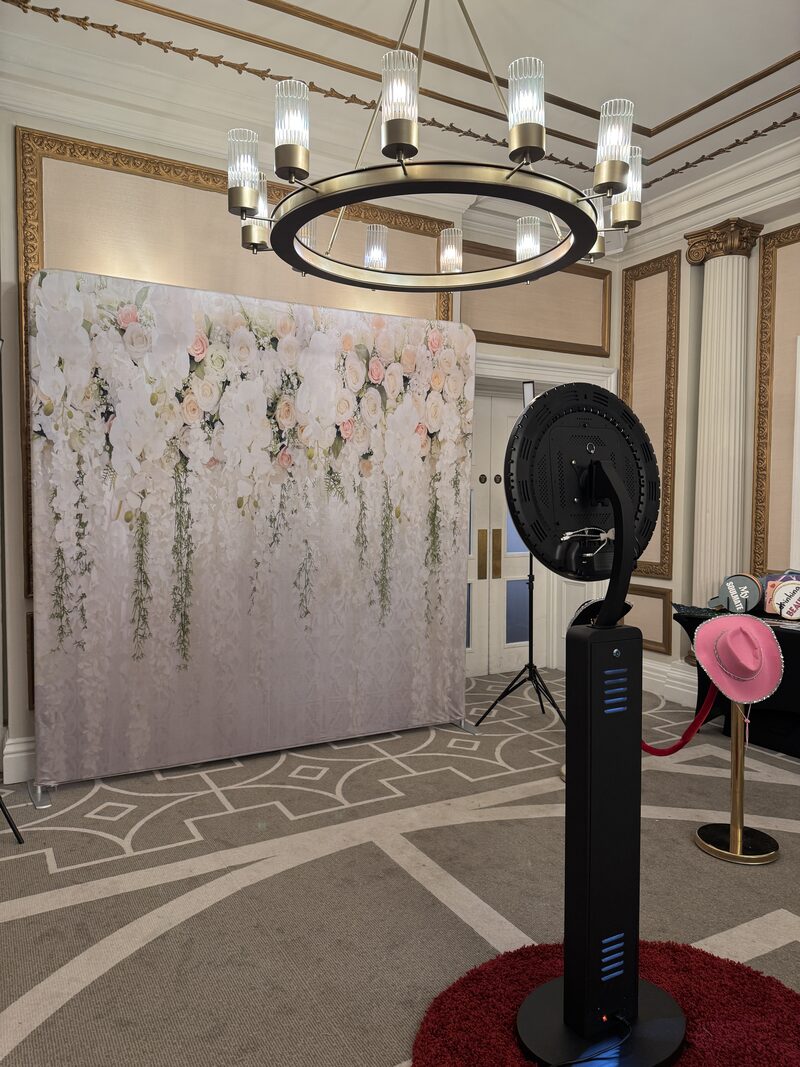 Aura ring-light pod set up with a flower wall at an elegant venue